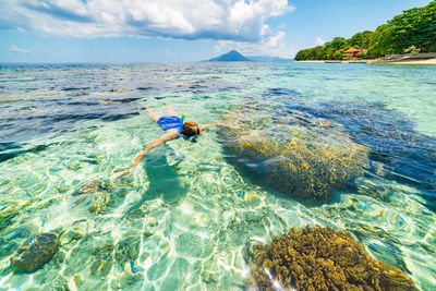 Man in sea against sky