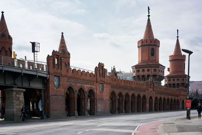 Road by historic building in city against sky