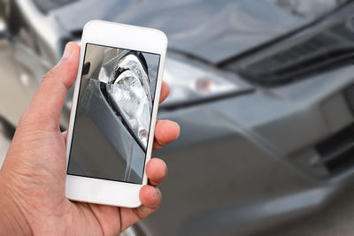 Close-up of hand photographing car