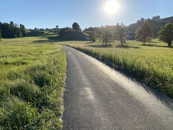 Road amidst field against sky