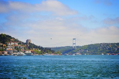 Sea by city buildings against sky