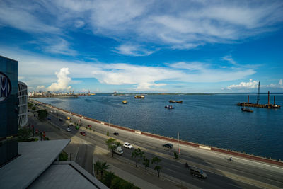High angle view of sea by city against sky