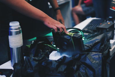 Midsection of man working with wine bottles