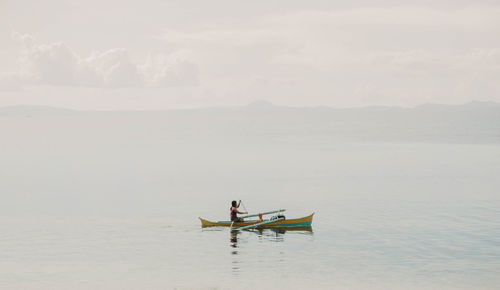 Men on boat in sea against sky