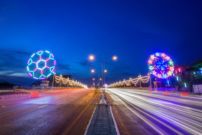 Light trails on road against sky at night