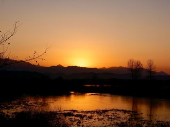 Scenic view of lake against orange sky