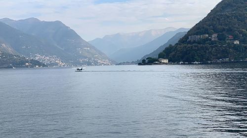 Scenic view of sea and mountains against sky