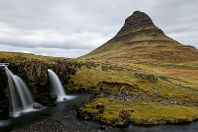 Scenic view of waterfall against sky