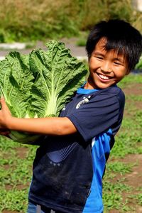 Portrait of smiling boy holding leaf