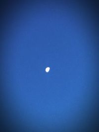 Low angle view of moon against blue sky