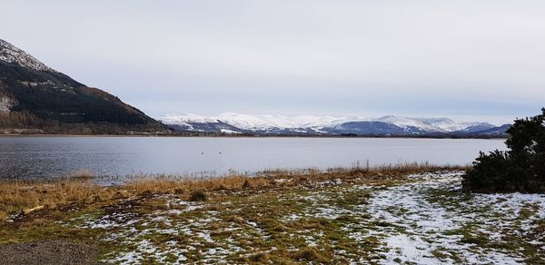 Scenic view of lake against sky during winter