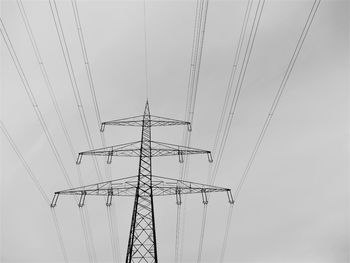 Low angle view of electricity pylon against clear sky