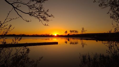 Scenic view of lake against orange sky