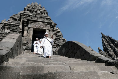 People at temple against sky