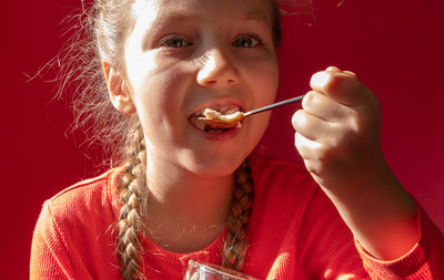 Child eating yogurt jelly on pink background dairy product kids diet healthy homemade breakfast menu
