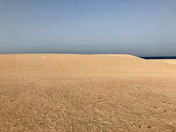 Scenic view of beach against clear sky