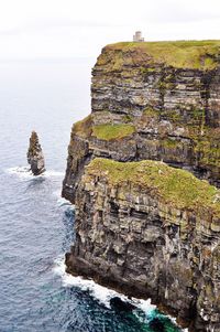 Rock formation by sea against sky