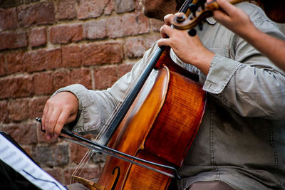 Midsection of man playing guitar