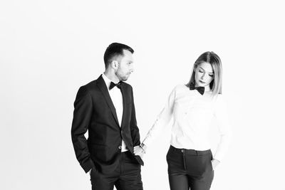 Young couple standing against white background