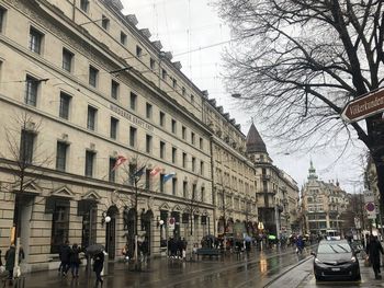 People walking on road amidst buildings in city