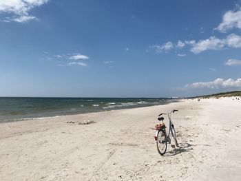 Bicycle on beach against sky