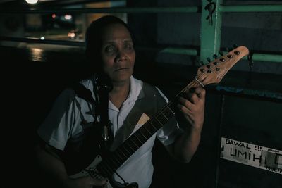 Portrait of young woman standing at night