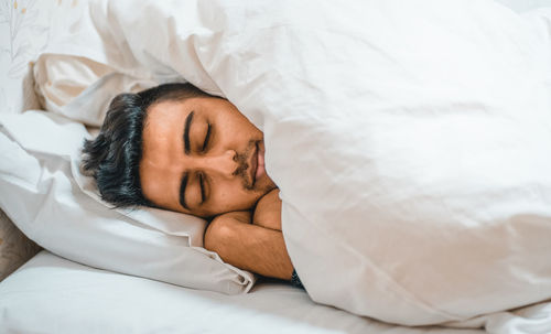 Portrait of man sleeping on bed