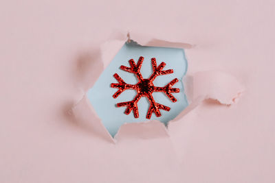 Christmas minimalistic concept. snowflake in a torn paper hole. flat style, top view, place for text