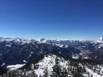 Scenic view of snowcapped mountains against clear blue sky