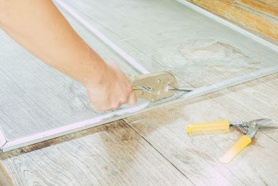 Cropped hand of carpenter working on wood