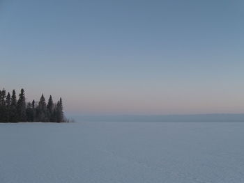 Scenic view of snow covered land against clear sky