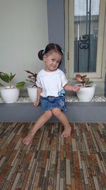 Cute girl sitting by plants