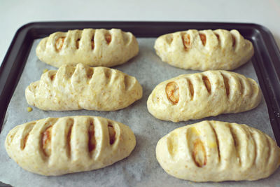 High angle of raw bun pastries on baking sheet