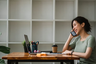 Woman sitting on table at home