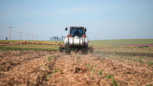 Tractor on agricultural field against sky
