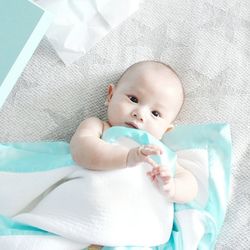 High angle view of baby playing with blanket on bed at home