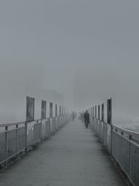 Man walking by sea against sky