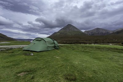 Tent on field against cloudy sky