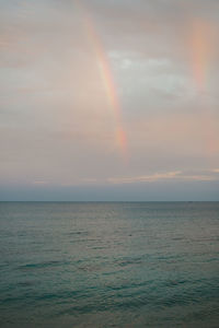 Scenic view of rainbow over sea against sky