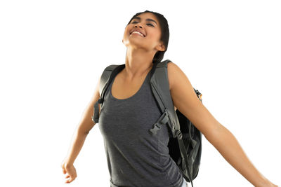 Young woman looking away while standing against white background