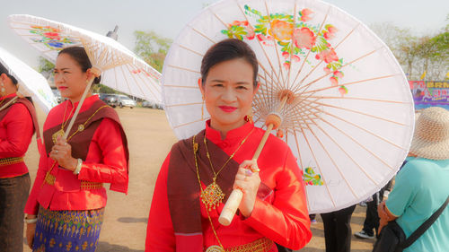 People in traditional clothing standing against the wall