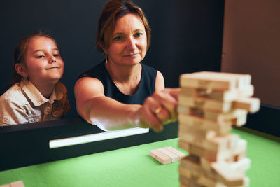 Portrait of woman playing with toy blocks on table