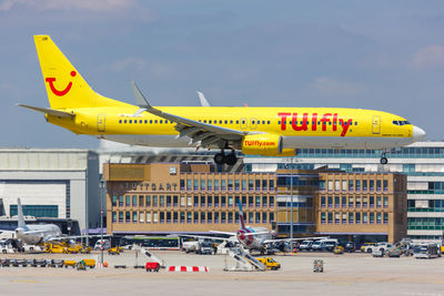 Yellow airplane flying against sky