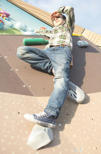 Low angle view of boy climbing on wall