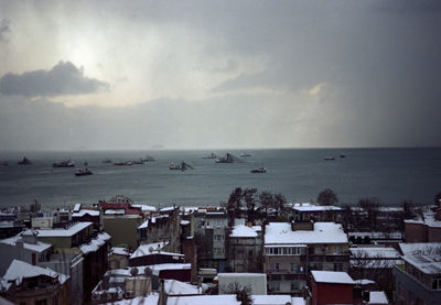 High angle view of cityscape by sea against sky