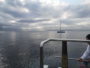 Rear view of man looking at sea against sky