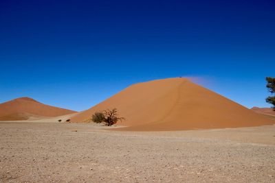 Scenic view of desert against clear blue sky