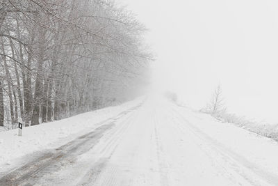 Winter road snowfall. an empty rural road without cars, covered with snowdrifts. 