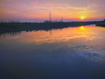 Scenic view of lake against romantic sky at sunset