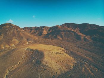 Scenic view of mountains against clear blue sky